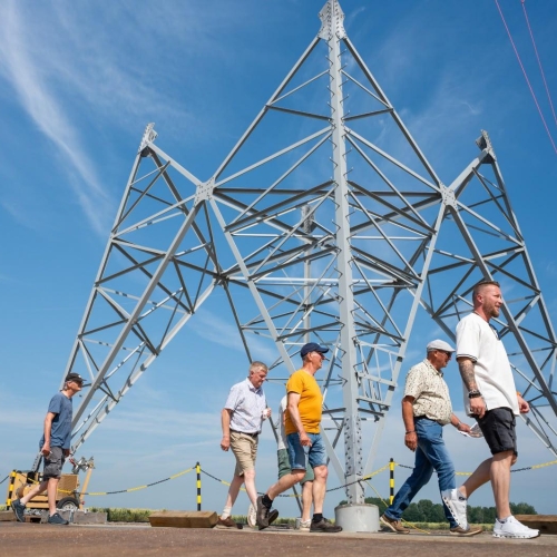 Dag van de Bouw - Mensen lopen voor voet van mast