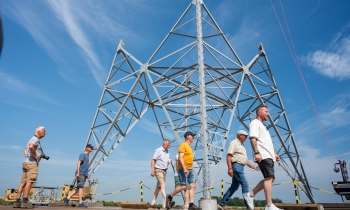 Dag van de Bouw - Mensen lopen voor voet van mast