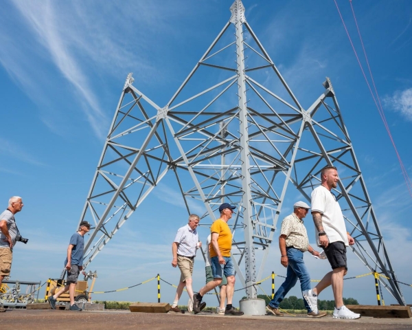 Dag van de Bouw - Mensen lopen voor voet van mast